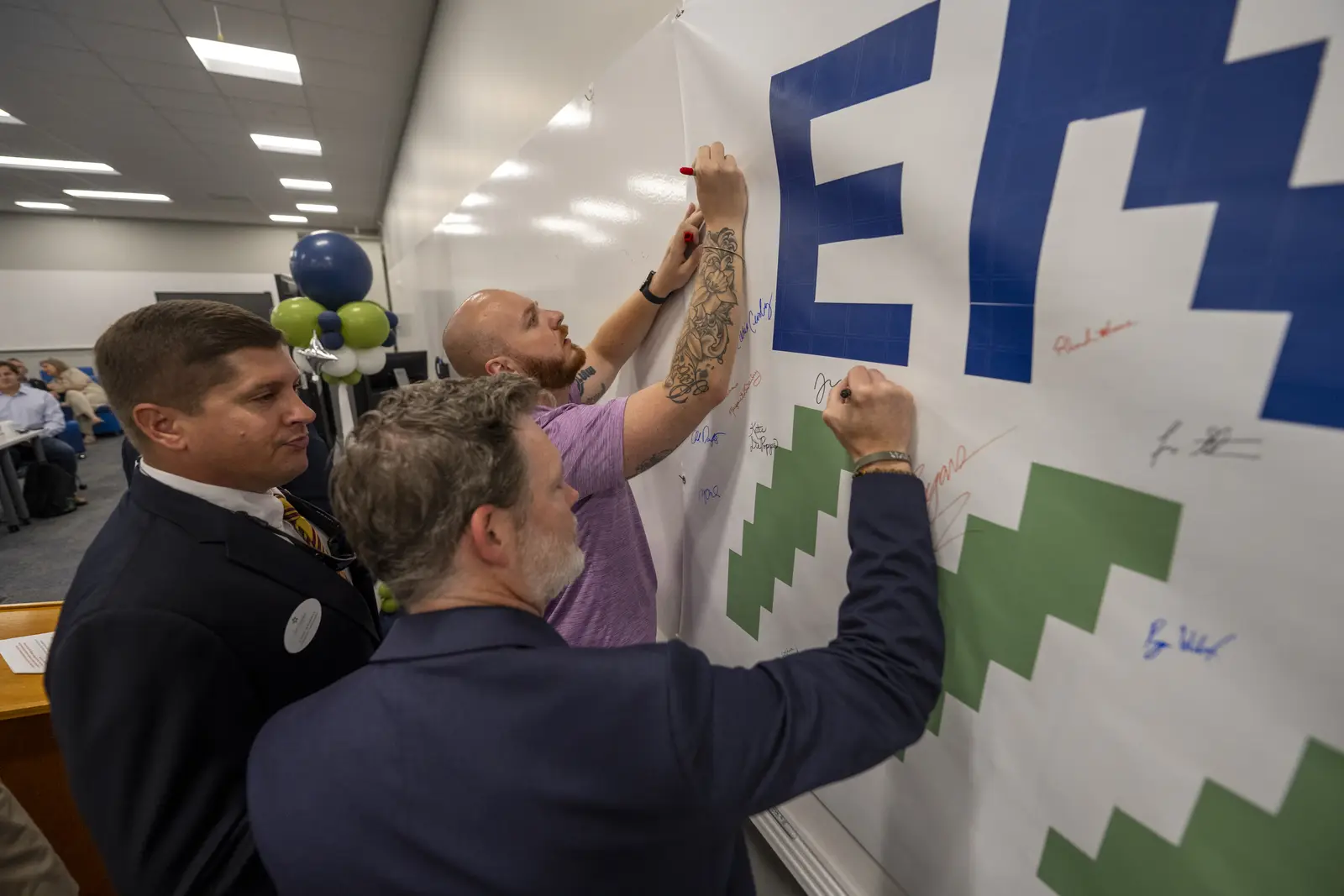 Attendees signing the Envision 2047 vision wall